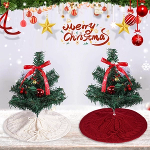 Detail of mini Christmas trees with cream and red cable knit skirts and red ribbons