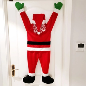 Detail of a climbing Santa Claus door hanging made of red plush fabric and green gloves