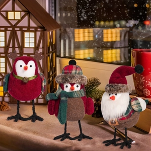 Detailed close-up of three plush Christmas birds with festive hats and reindeer antlers