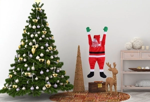 Close-up of a plush Santa Claus hanging ornament next to a decorated Christmas tree