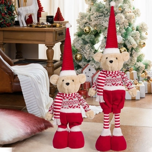 Close-up of beige plush teddy bears wearing festive red snowflake sweaters and scarves