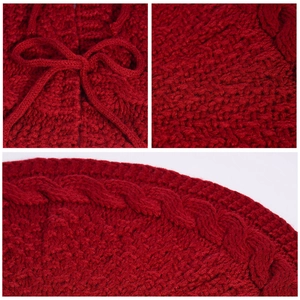 Close-up of red knit Christmas tree skirt with cable stitch edges and a ribbon bow