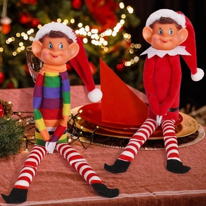 Set of two long-legged Christmas elf dolls with colorful sweaters on a festive table
