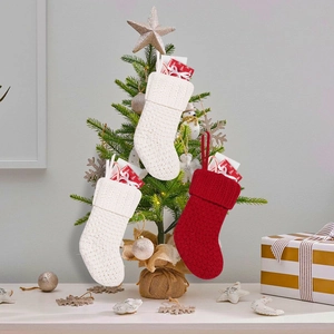 Nahaufnahme von Strick-Weihnachtssocken mit dicker Webstruktur an einem geschmückten Baum