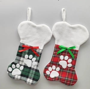 Detail view of bone-shaped Christmas stockings with plaid patterns and plush paw appliques