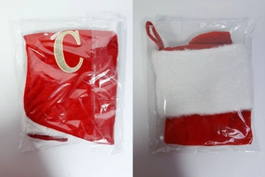 Detail of red velvet Christmas stocking with gold glitter letter C and white plush trim