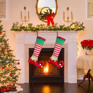 Detail of festive elf-shaped Christmas stockings with red and white stripes and bells