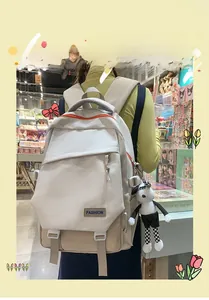 Détail du grand sac à dos bicolore crème et marron avec pendentif en peluche