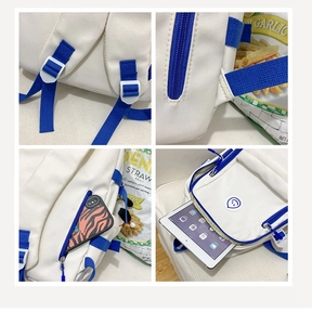 Detail view of white canvas backpack showing blue zippers, side pockets, and inner storage