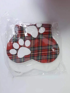 Macro detail of red plaid Christmas paw print stockings for pets in clear packaging