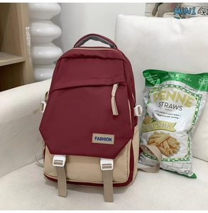 Vue détaillée du sac à dos bicolore bordeaux et beige avec fermetures à boucles