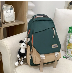 Détail d'un sac à dos en nylon vert et beige avec étiquette mode et porte-clé