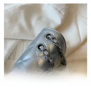 Macro detail of silver quilted chain bag featuring high-quality metallic hardware