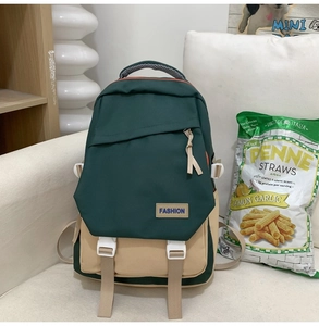 Détail du sac à dos bicolore vert et beige avec sangles renforcées et logo brodé