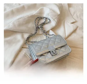 Detail of silver quilted handbag with metallic finish and metal chain shoulder strap