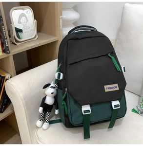 Détail du sac à dos noir et vert avec écusson mode et pendentif chiot mignon
