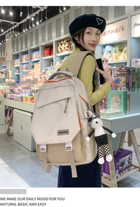 Vue latérale du sac à dos scolaire beige avec zips orange et porte-clé panda