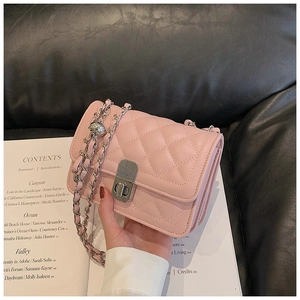 Detailed close-up of pink quilted crossbody bag with silver chain and metal twist lock
