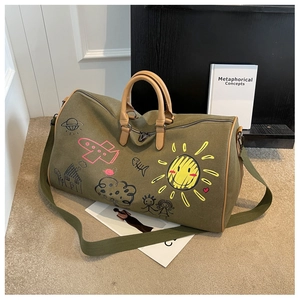 Detail of olive canvas travel bag with leather handles and playful doodle patterns