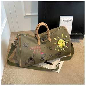 Detail of army green canvas travel bag with colorful graffiti and leather handles