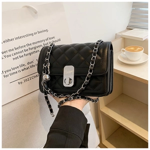 Close-up of black quilted leather shoulder bag with silver metal twist lock and chain strap