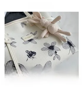 Détail du cabas en toile fleurie avec poignées en cuir et charmant pendentif lapin