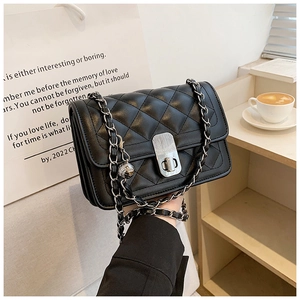 Close-up of black quilted leather chain bag with silver twist-lock and metal strap