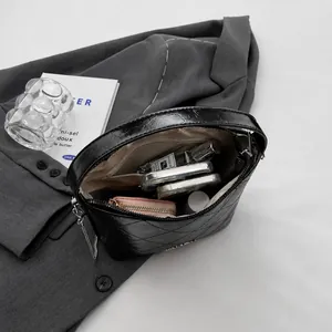 Interior capacity of the quilted chain bag showing space for wallet and cosmetics