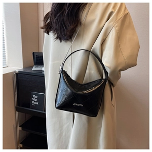 Detail of quilted leather handbag featuring chain strap and Jingpin logo in home setting