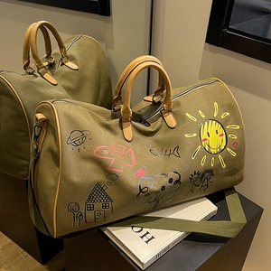 Olive canvas travel tote bag with colorful playful graffiti and leather handles