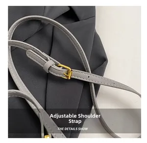 Detail of adjustable gray leather shoulder strap with gold buckle and fine stitching