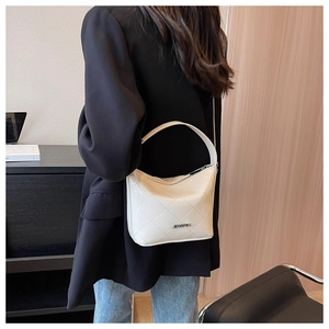 Close-up of cream quilted leather hobo bag with a refined metal chain strap