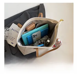 Interior view of large beige tote bag showing high capacity for tablets and essentials