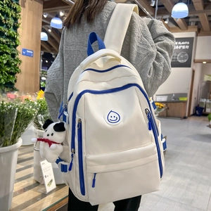 Large beige and blue school backpack with smiley patch and cute puppy keychain