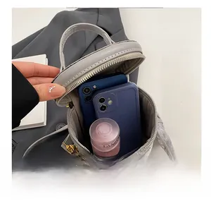 Internal view of grey mini bucket bag showing storage capacity for phones and cosmetics