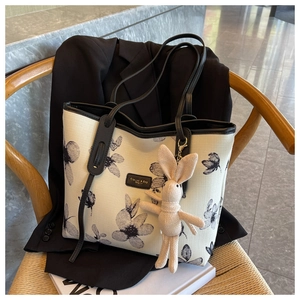 Sac fourre-tout en toile à motif fleuri avec charme lapin sur une chaise tressée