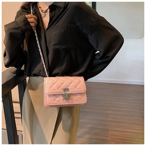 Close-up of pink quilted leather bag with vintage metal lock and chain shoulder strap