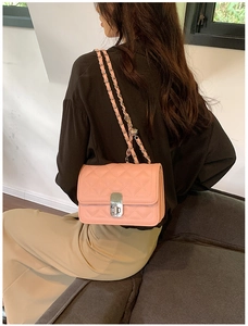 Pink quilted chain bag detail with gold metal lock and leather interwoven shoulder strap
