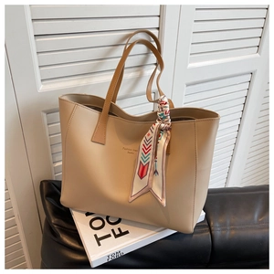Detail of khaki tote bag with silk scarf handle and Fashion trend Souku print decoration