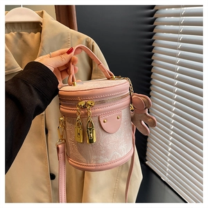 Detail of pink jacquard bucket bag with golden lock pendants and a bunny charm