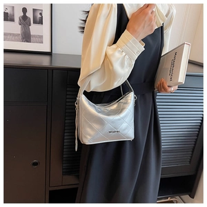 Close-up of silver quilted hobo bag with metallic finish and metal tassel detail