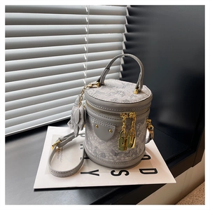 Close-up of a small grey bucket bag with floral patterns and gold hardware detail