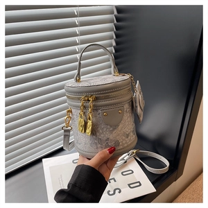 Detail of grey mini bucket bag with gold lock zipper and elegant wavy pattern