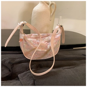 Detailed view of pink jacquard fabric texture and leather strap on a crescent bag