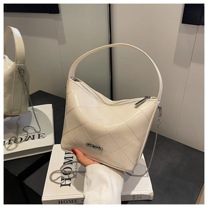 Close-up of cream quilted bucket bag with JINGPIN metal logo and gold chain strap