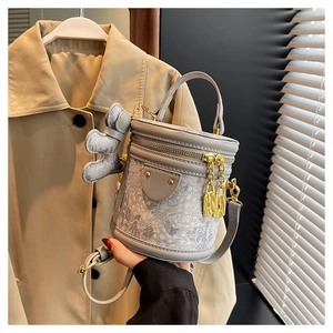 Detailed macro view of the grey cylinder bucket bag showing fine textured fabric and zipper
