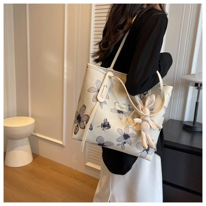 Canvas tote bag with floral print and rabbit charm shown on shoulder for daily commute