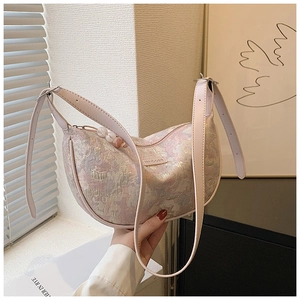 Detail of light pink floral jacquard fabric and pearl zipper puller on the moon bag