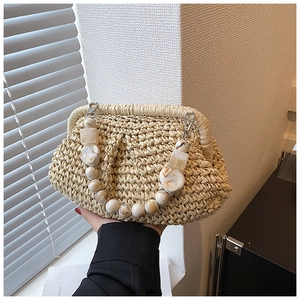 Close-up of woven straw handbag featuring marble texture beaded handle and metal clasp