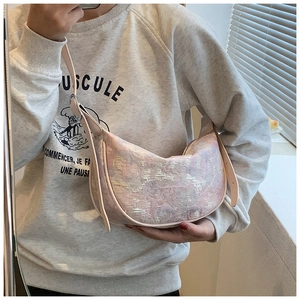 Detailed close-up of a pink jacquard crescent bag with adjustable leather shoulder strap
